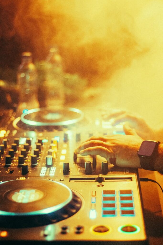 Dynamic scene of a DJ mixing music with colorful lights and smoke at night.